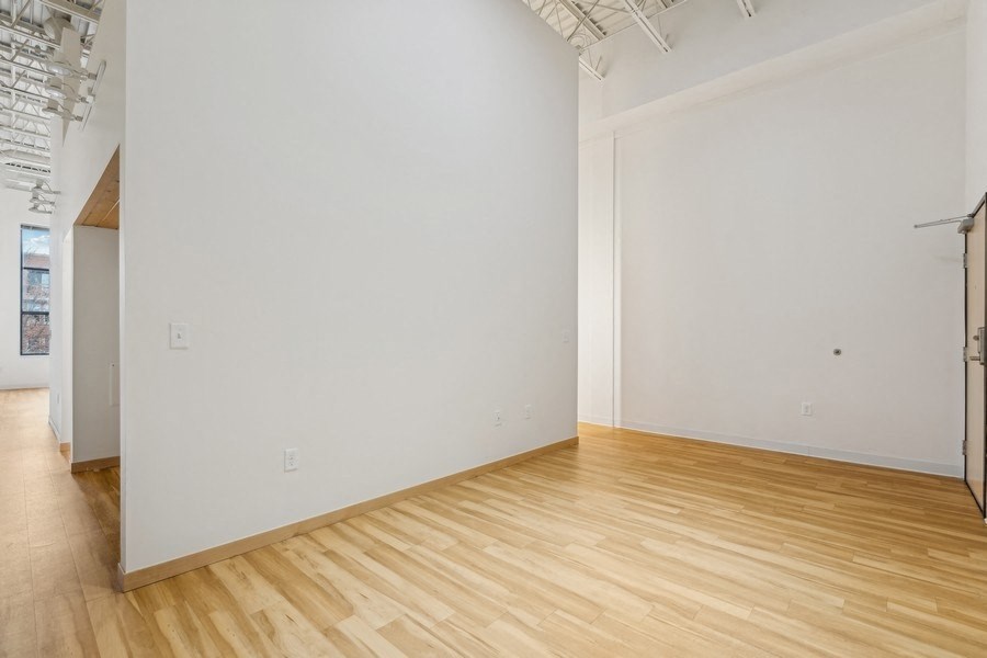 A room with wooden flooring and white walls.
