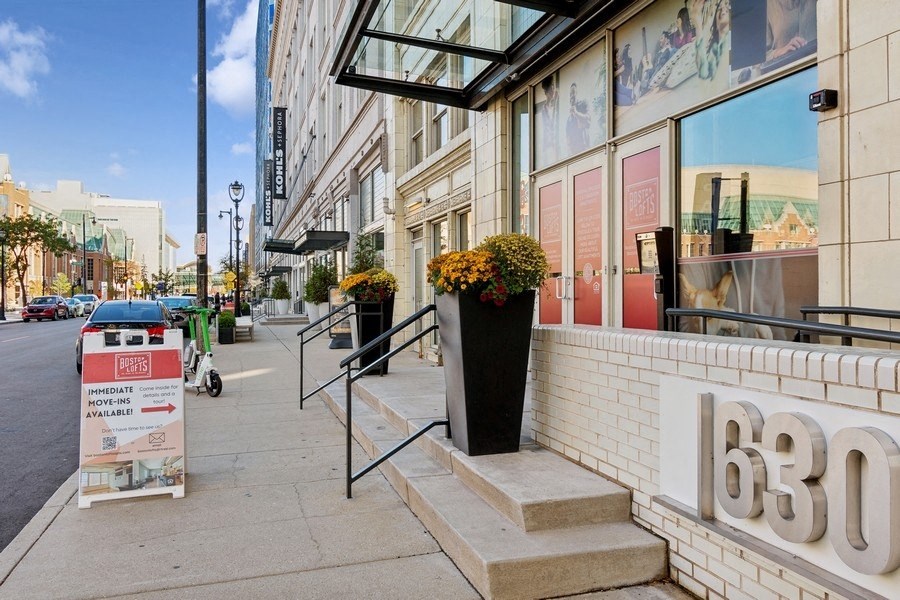 a bicycle parked in front of a building with flowers on the sidewalk