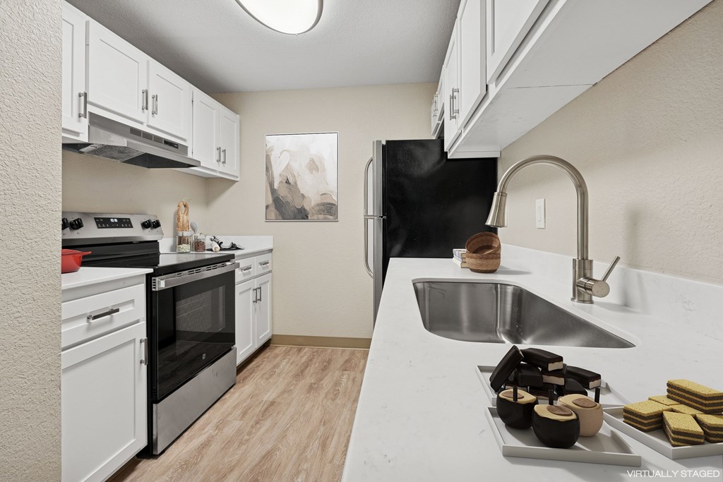 A kitchen with a black refrigerator, stove, and oven.