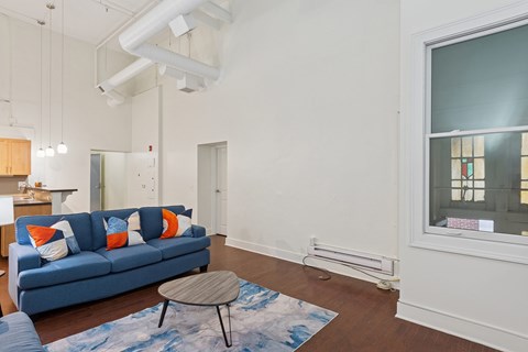 A living room with a blue couch and a small table.