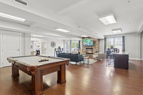 A pool table is in the middle of a room with a fireplace.