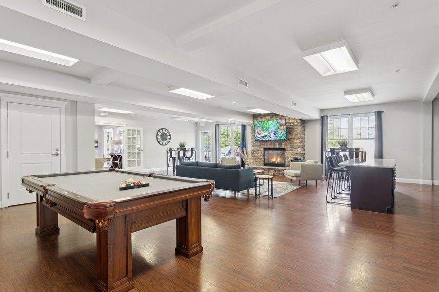 A pool table is in the middle of a room with a fireplace.