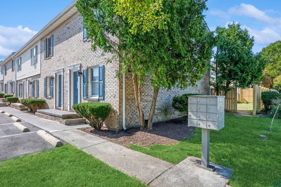 a brick building with blue shutters and a mailbox in front of it at Fort Collier Terrace, Virginia, 22601