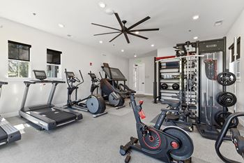 a home gym with exercise equipment and a ceiling fan