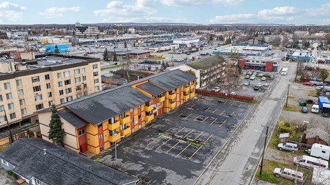 A parking lot in front of a multi-story building.