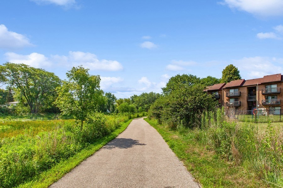 a path leading to a building with a red roof