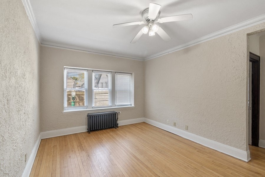 an empty living room with a ceiling fan and a window