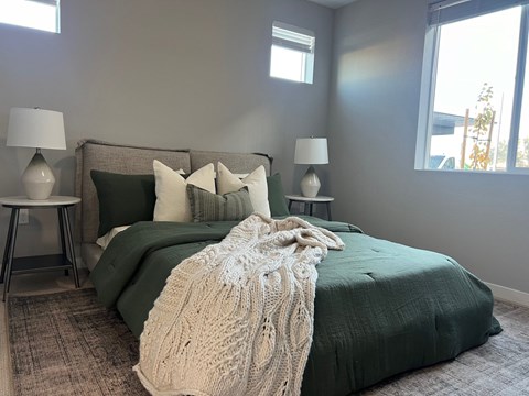 a bedroom with a bed with a blanket and pillows