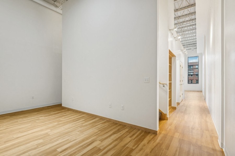 A long hallway with wood floors and white walls.