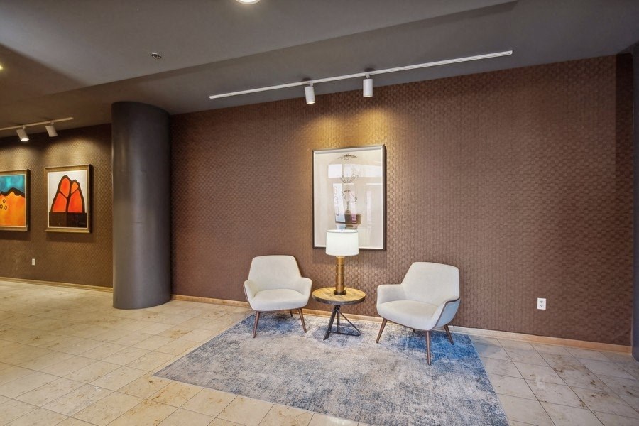 a lobby with two chairs and a table and a painting