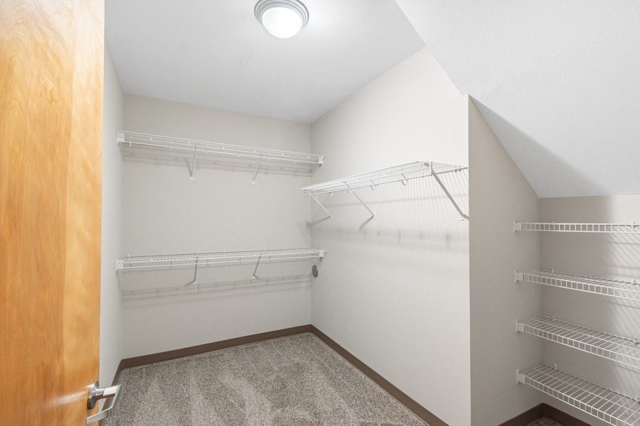 the spacious closet in the bedroom of a home with white walls and empty shelves
