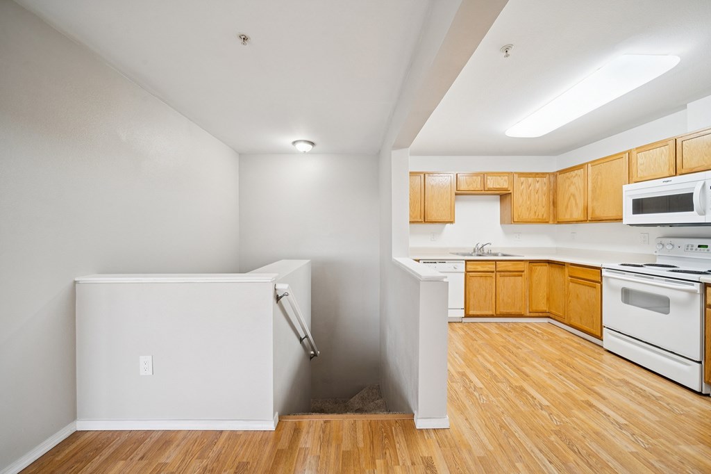 A kitchen with wooden cabinets and a white fridge.