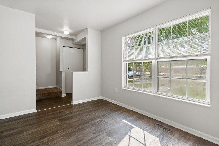 an empty living room with a large window and wooden floorsat Mason Street Townhomes, Grand Rapids, Michigan