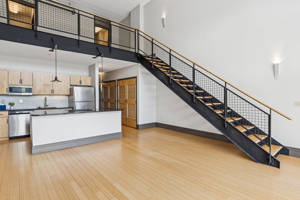 A kitchen with a staircase leading to the upper floor.