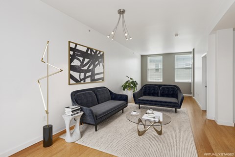A living room with a black couch and a coffee table.