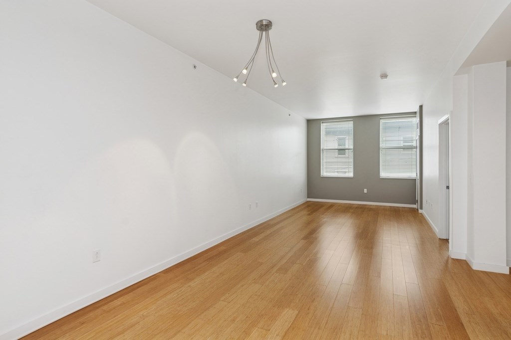 A room with wooden floors and a chandelier.