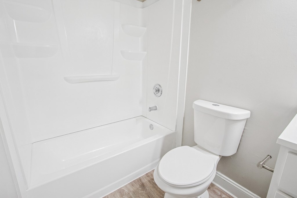 A white toilet in a small bathroom with a walk-in shower.
