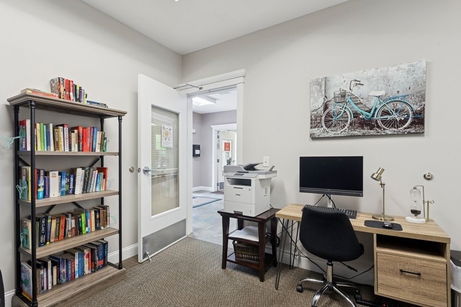 A room with a desk, chair, and bookshelf.