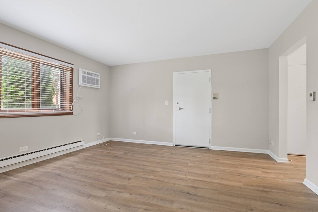 A room with a white door and a window with blinds.
