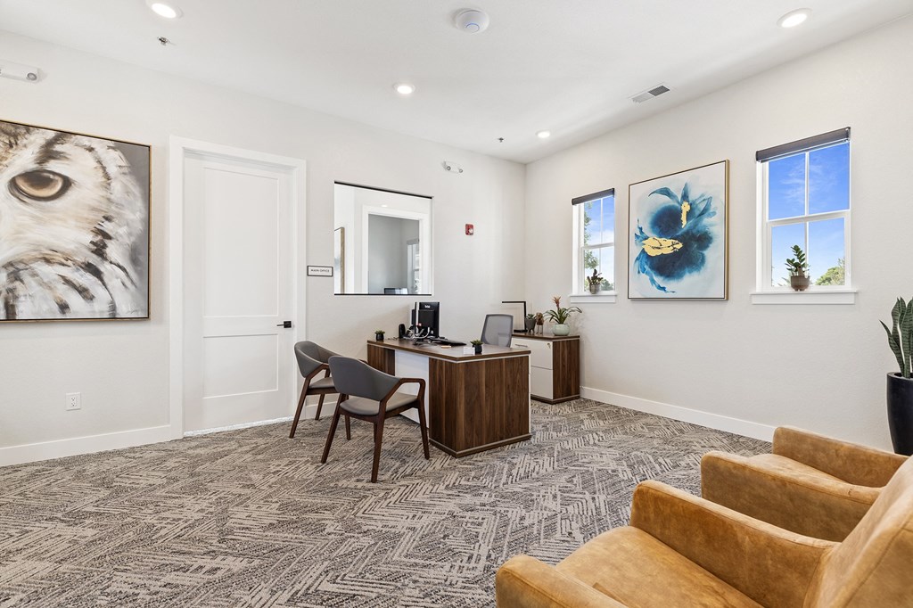 an office area with a desk and chairs and a couch