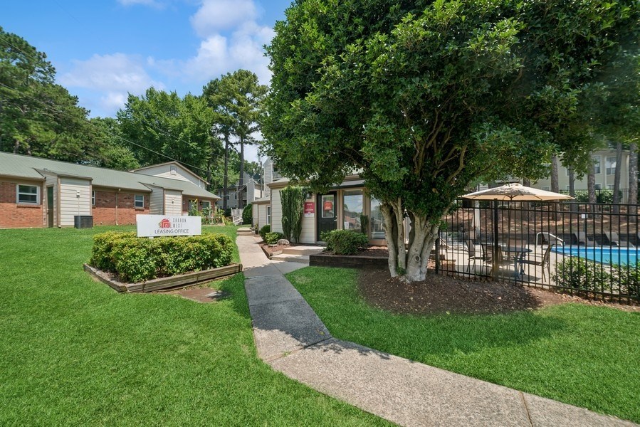 A residential area with a pool and a sign in the foreground.