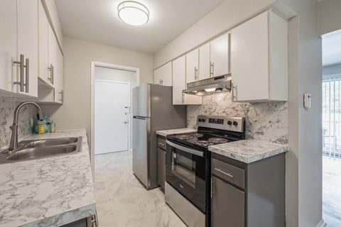 a kitchen with stainless steel appliances and marble counter tops