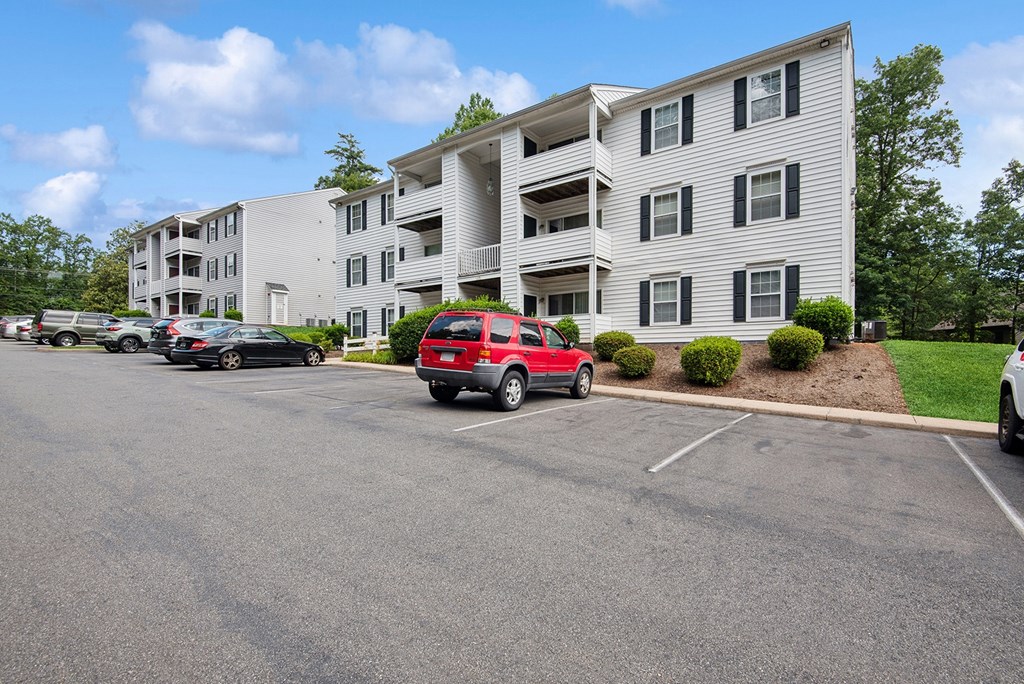 Parking lot in front of a white apartment building.