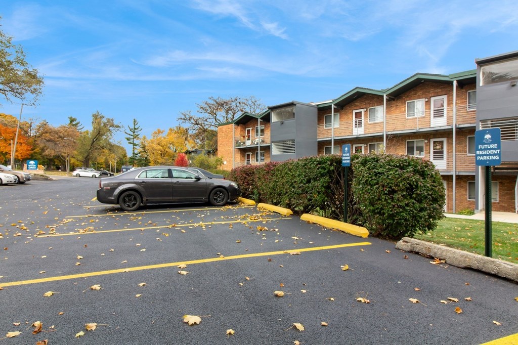 a car parked in a parking lot in front of an apartment building at River Oaks, North Aurora, Illinois