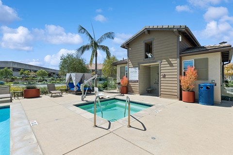 A pool with a slide and a house in the background.