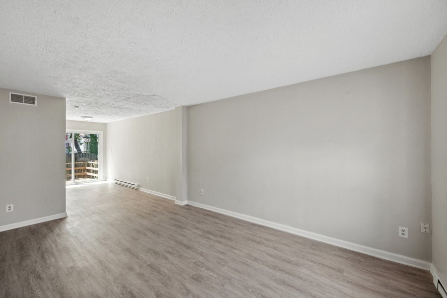 an empty living room with hardwood floors and grey walls at Fort Collier Terrace, Winchester, VA 22601