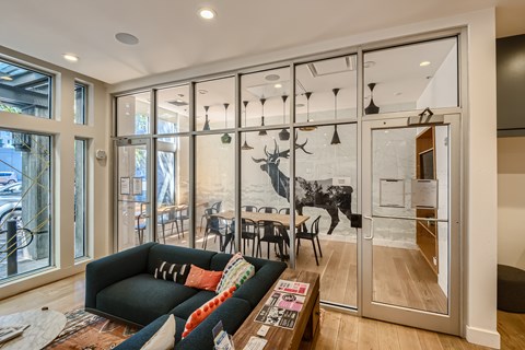 A living room with a black couch and a coffee table in front of a glass door.