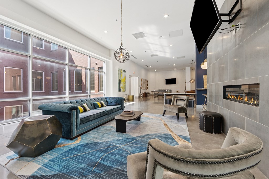 A modern living area with a blue rug and a blue sofasofa.
