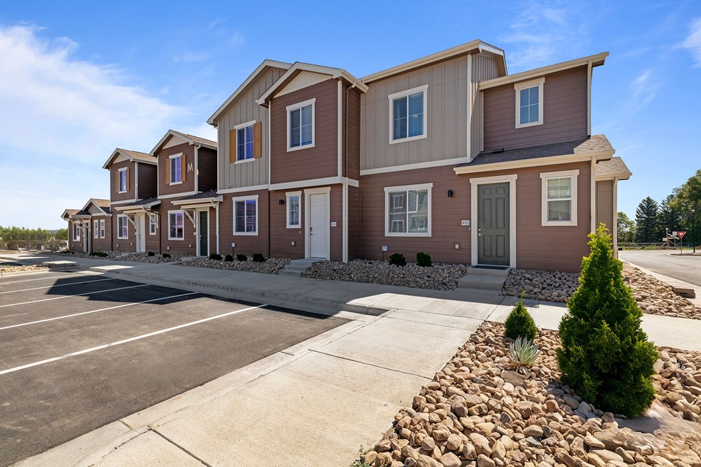 a row of townhomes with a sidewalk in front of them