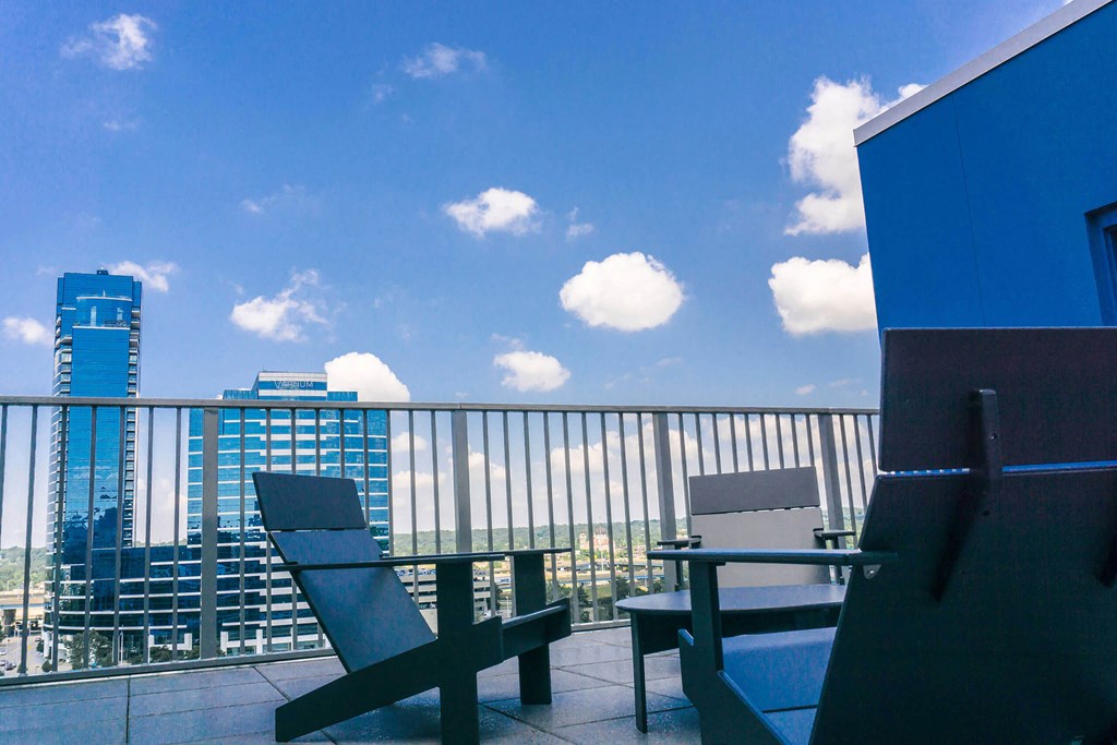 a balcony with a table and chairs and a city in the background at The Rowe, Grand Rapids, Michigan