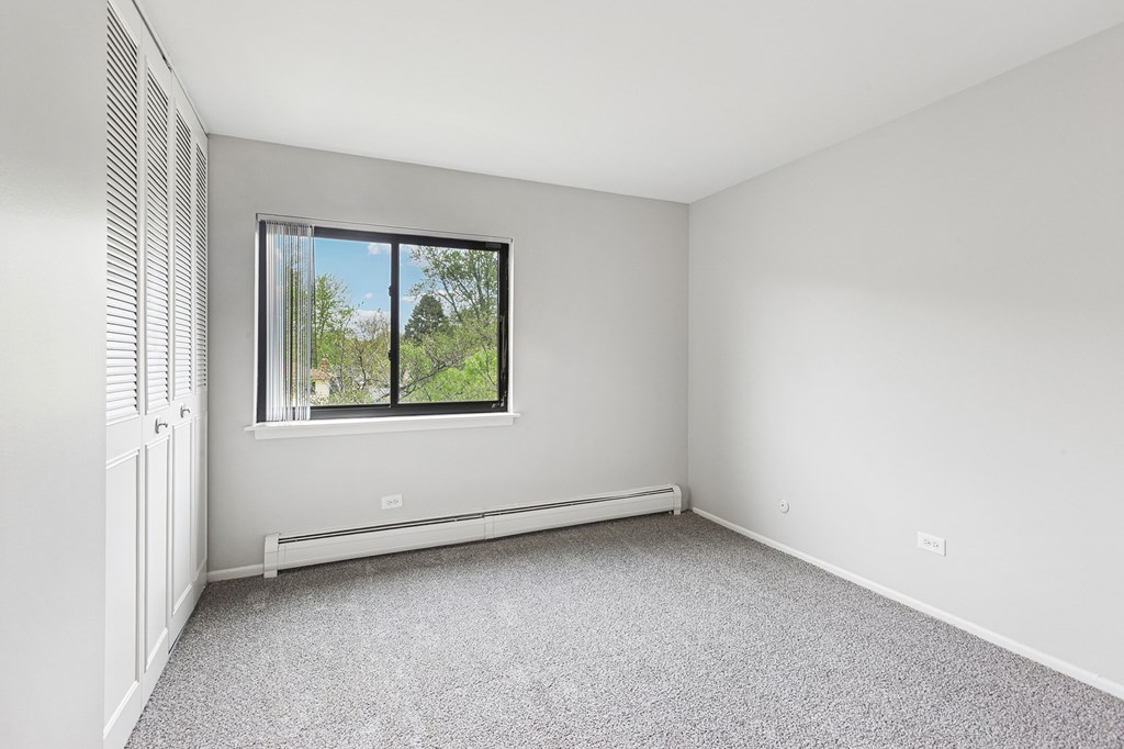 Bedroom with a window and a radiator on the wall.