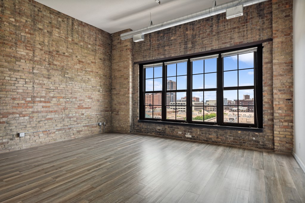 an empty room with a large window and brick wallsat Gaar Scott Historic Lofts, Minnesota
