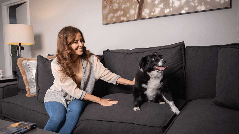 a woman sitting on a couch with her dog at The Township at St. Charles, Illinois