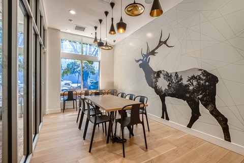 A dining room with a large deer mural on the wall.