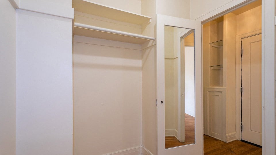 the closet in the master bedroom has a mirrored door and a door to the hallway