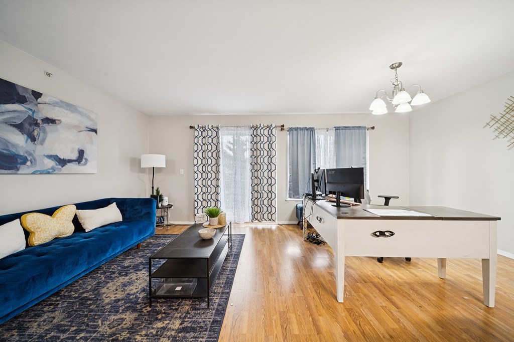 A blue couch sits in a living room with a television and a pool table.