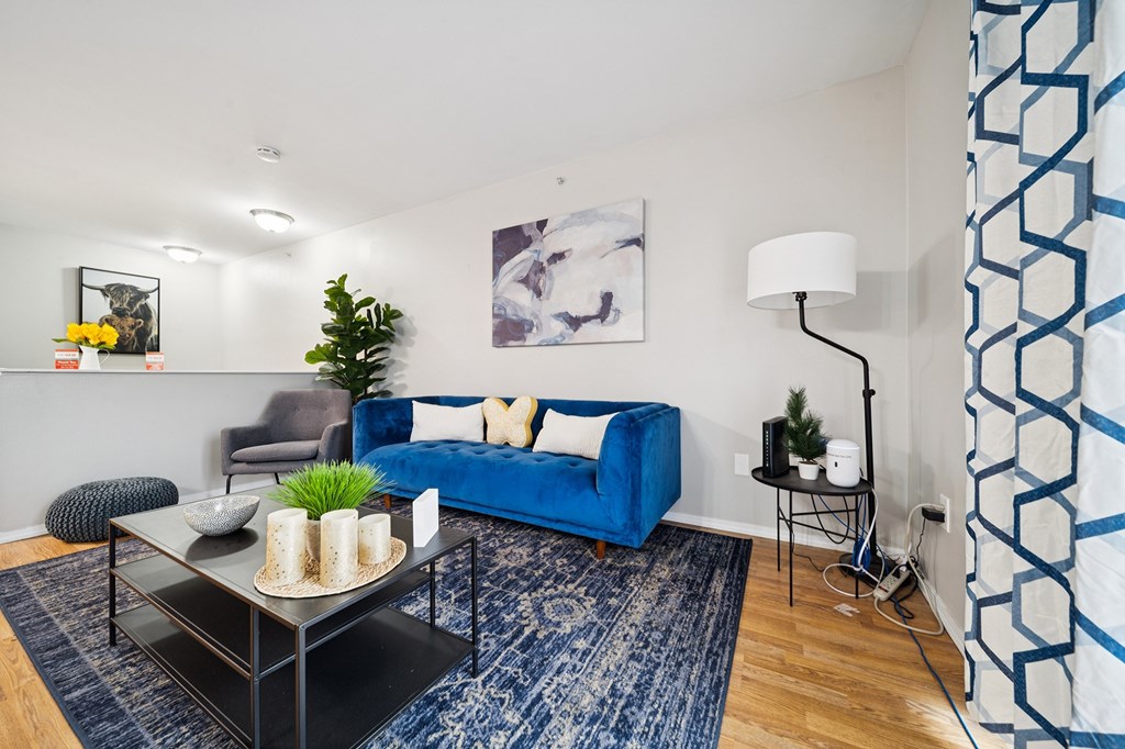 A living room with a blue couch and a black coffee table.