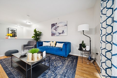 A living room with a blue couch and a black coffee table.