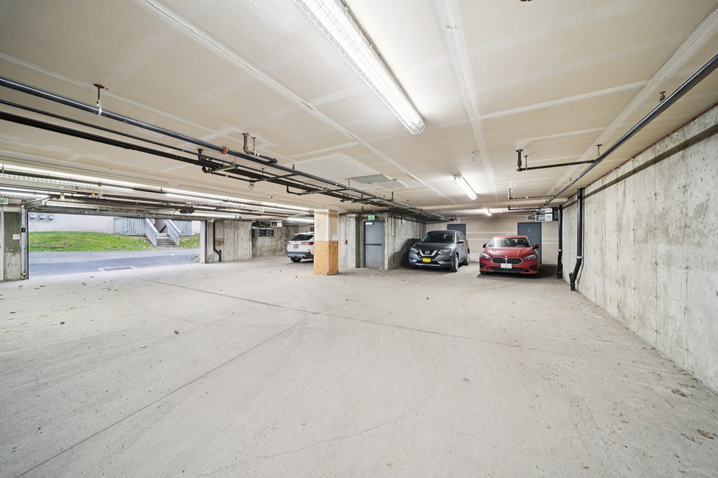 A large, empty parking garage with a red car parked in the distance.
