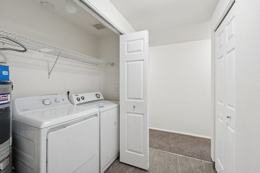 a white laundry room with white appliances and a white door