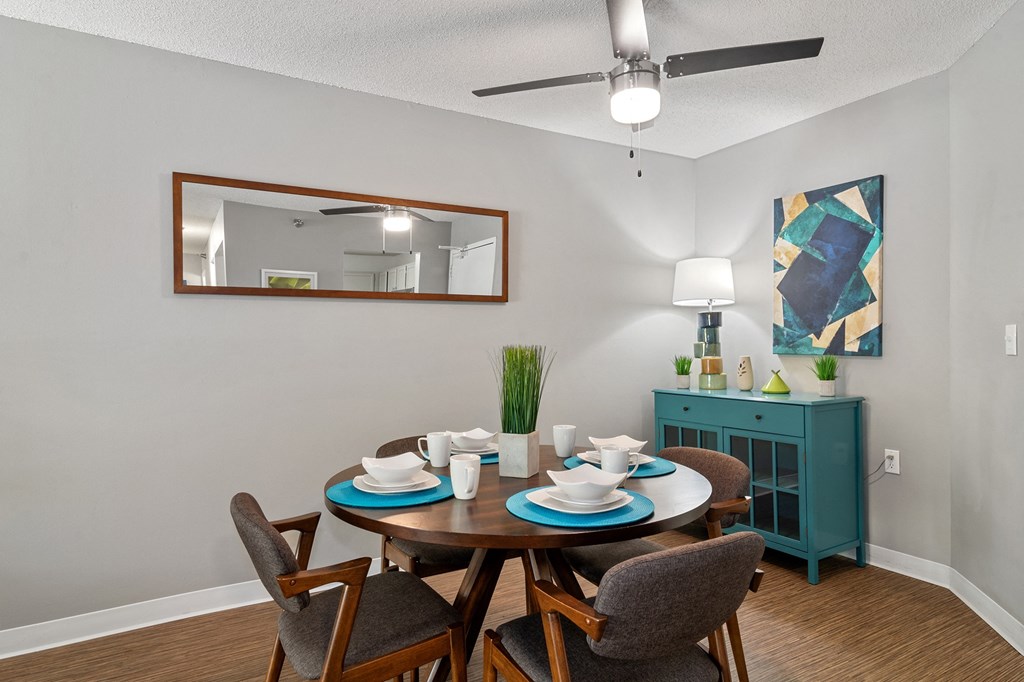 a dining room with a table and chairs and a ceiling fan