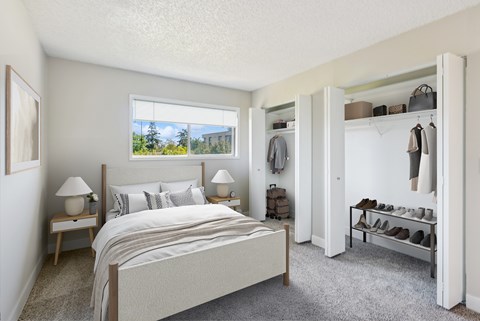 A bedroom with a large bed, a window with a view, and a shoe rack.