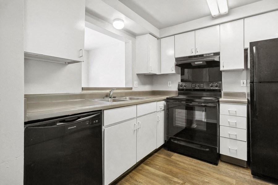 a kitchen with white cabinets and black appliancesat Mason Street Townhomes, Grand Rapids, Michigan