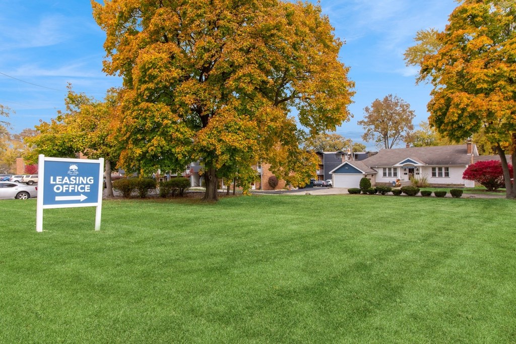 a lawn with a leasing office sign in front of a house at River Oaks, Illinois
