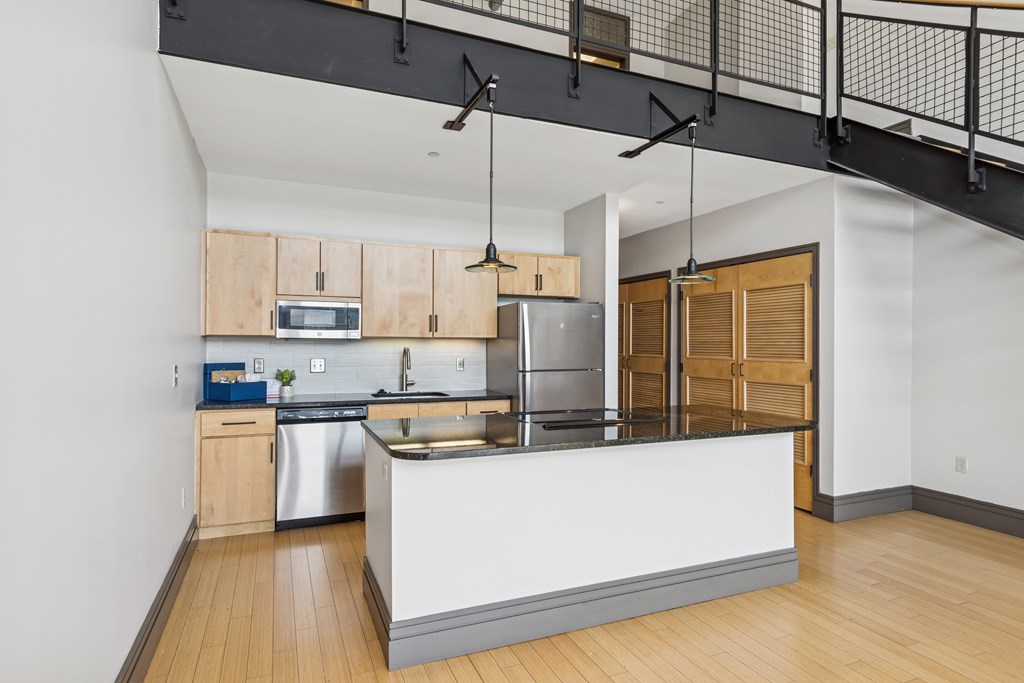 A modern kitchen with wooden cabinets and a white island.