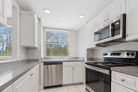 A kitchen with white cabinets and stainless steel appliances.